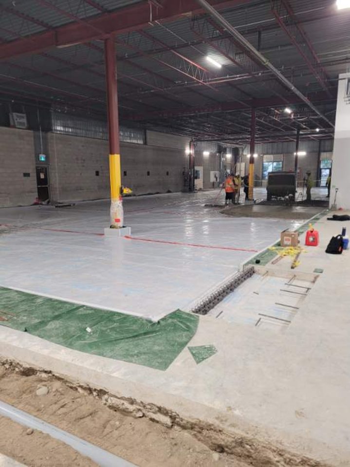 Placement of new 6-inch steel fiber reinforced seamless concrete floor slab.