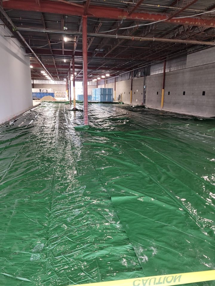 Installation of 10 mil polyethylene vapor barrier below floor insulation.