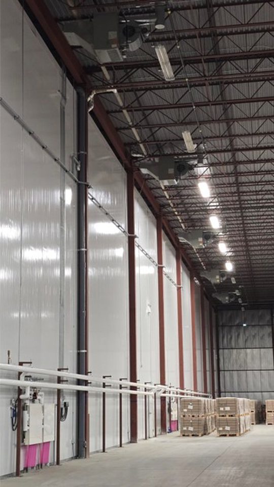 Natural gas unit heaters for interstitial space heating above freezer.