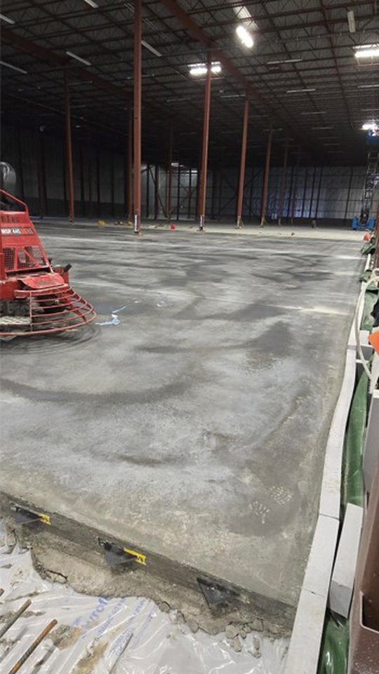 Finishing of 7-inch steel fiber reinforced concrete freezer floor slab.